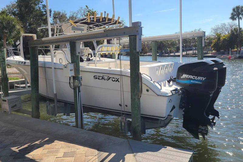 Slide: The Image of 2006 Sea Fox 287 Center Console boat with Mercury engine on a lift by the water. - 3