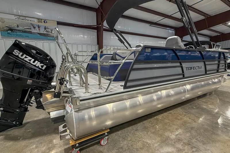 Slide: The Image of 2025 Trifecta 22UL CS pontoon boat with Suzuki outboard motor in a showroom. - 9