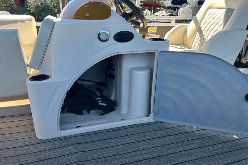 Slide: The Image of Open storage compartment on a 2022 Lexington 317 series boat, featuring white seating and striped flooring. - 15