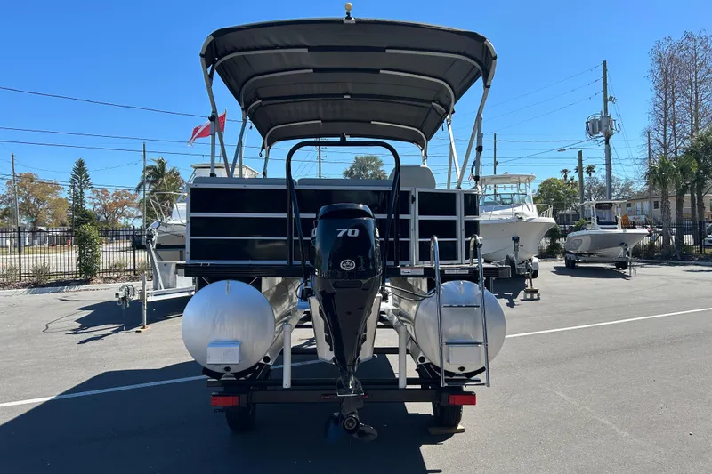Slide: The Image of 2022 Lexington 317 series pontoon boat with outboard motor, parked outdoors. - 3