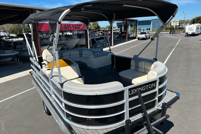 Slide: The Image of 2022 Lexington 317 series pontoon boat with canopy, parked in a marina. - 6