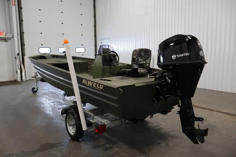 Slide: The Image of 2025 Alweld 1648 Marsh boat with Tohatsu motor in a garage setting. - 6