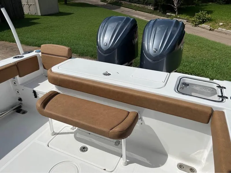 Slide: The Image of 2022 Sea Hunt Gamefish 27 boat interior with twin engines and cushioned seating. - 10