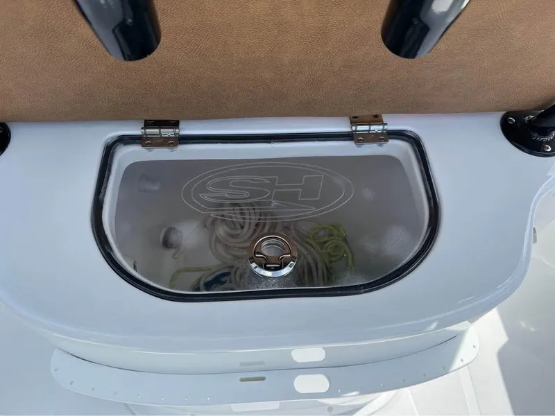 Slide: The Image of 2022 Sea Hunt Gamefish 27 boat storage compartment with clear lid and rope inside. - 11
