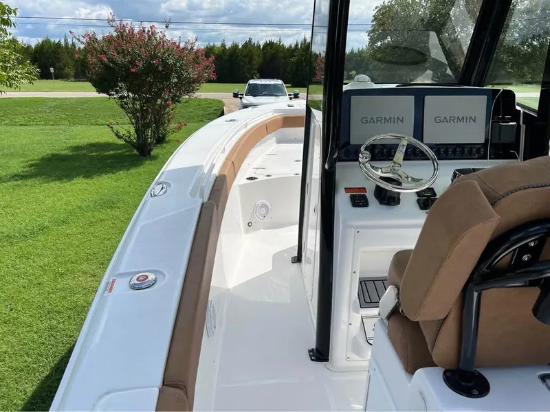 Slide: The Image of 2022 Sea Hunt Gamefish 27 boat interior with Garmin navigation, white and tan seating. - 8