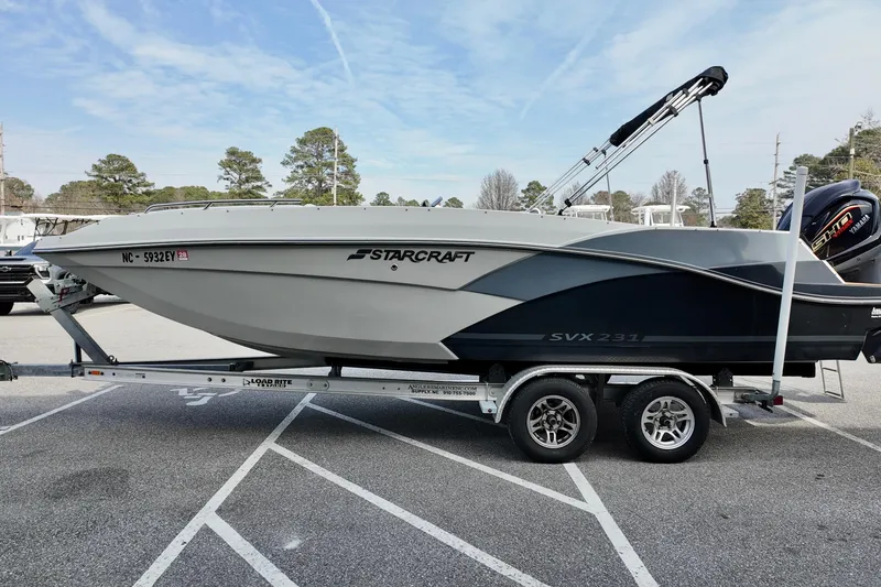 Slide: The Image of 2023 Starcraft SVX 231 OB boat on trailer in parking lot, side view. - 14