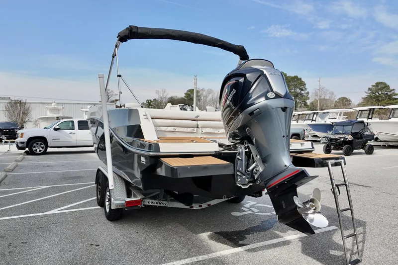 Slide: The Image of 2023 Starcraft SVX 231 OB boat with outboard motor on trailer in parking lot. - 16
