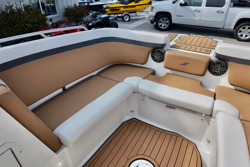 Slide: The Image of 2023 Starcraft SVX 231 OB boat interior with tan and white seating, wood-style flooring. - 8