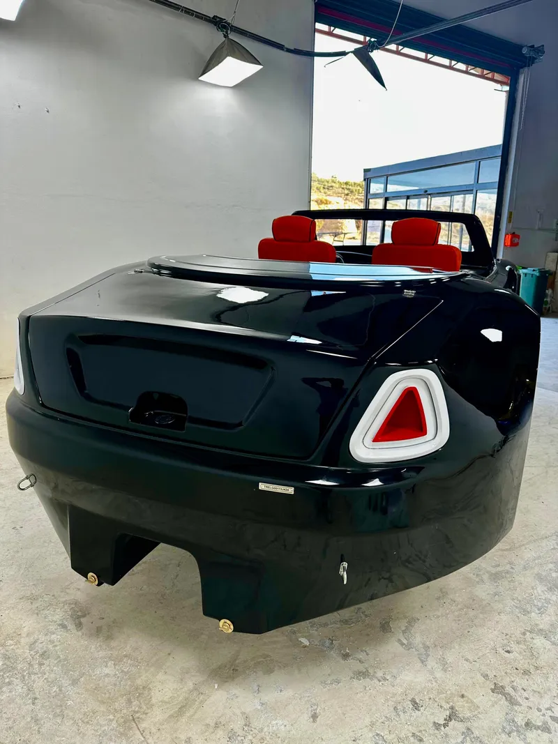 Slide: The Image of 2025 Fabbro Jet Car RR, sleek black design, red interior, in a modern garage setting. - 23