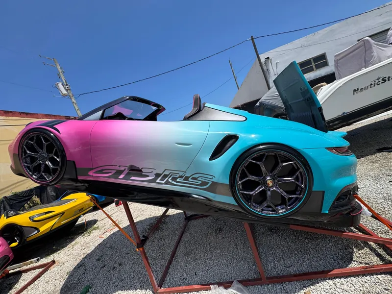 Slide: The Image of Fabbro Jet Car RR 2025 with gradient paint, displayed on a stand outdoors. - 33