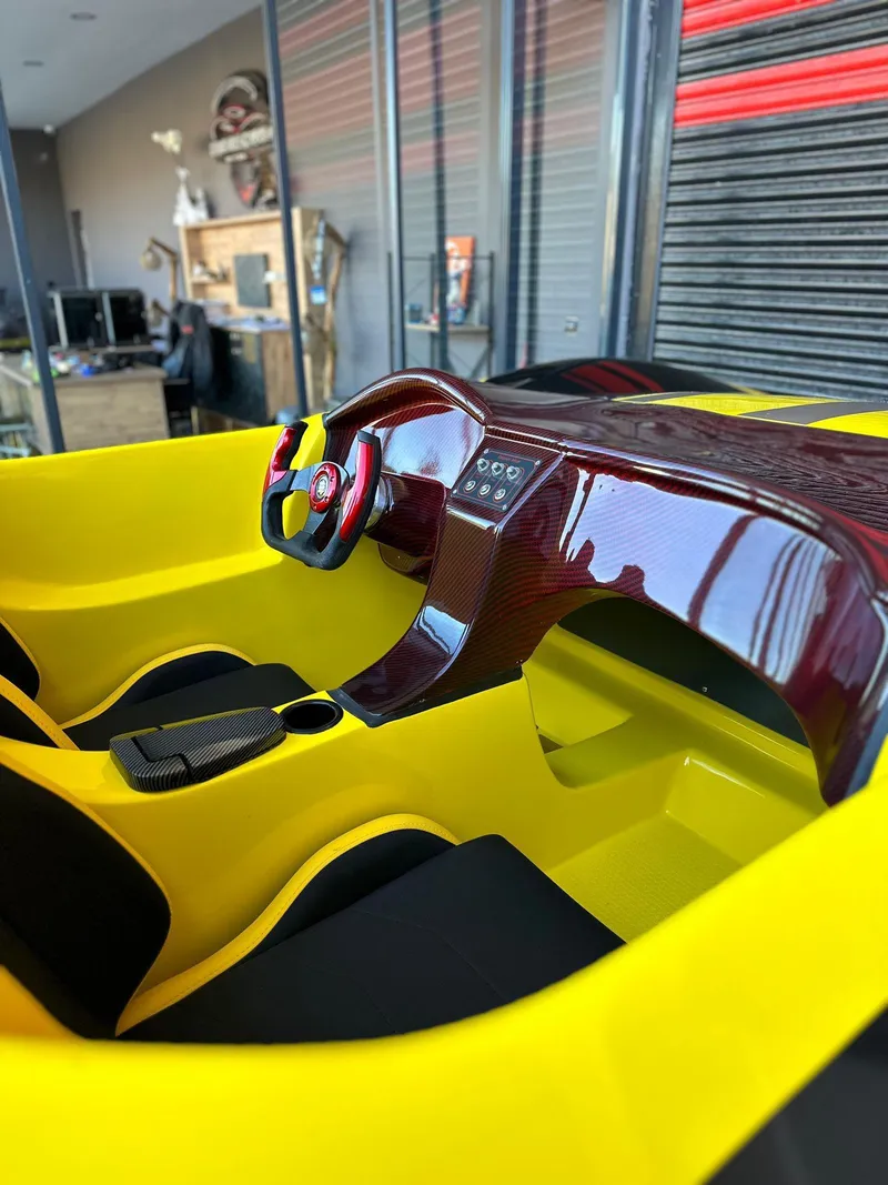 Slide: The Image of Yellow and red interior of 2025 Fabbro Jet Car RR, featuring sleek dashboard and steering wheel. - 35