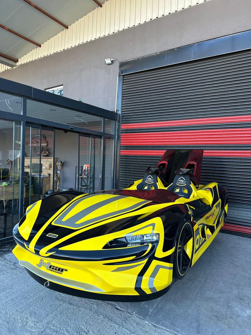Slide: The Image of 2025 Fabbro Jet Car RR in vibrant yellow and black design, parked outside a garage. - 40