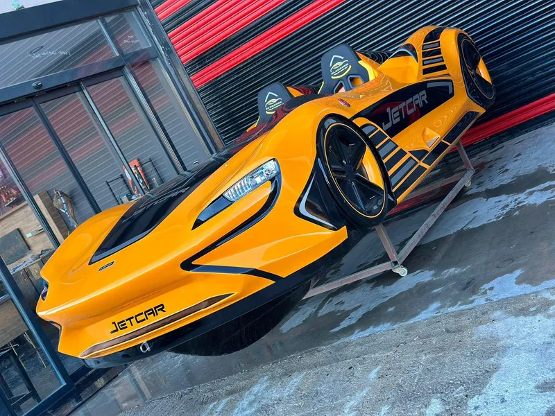 Slide: The Image of 2025 Fabbro Jet Car RR in vibrant orange, sleek design, displayed outdoors. - 44