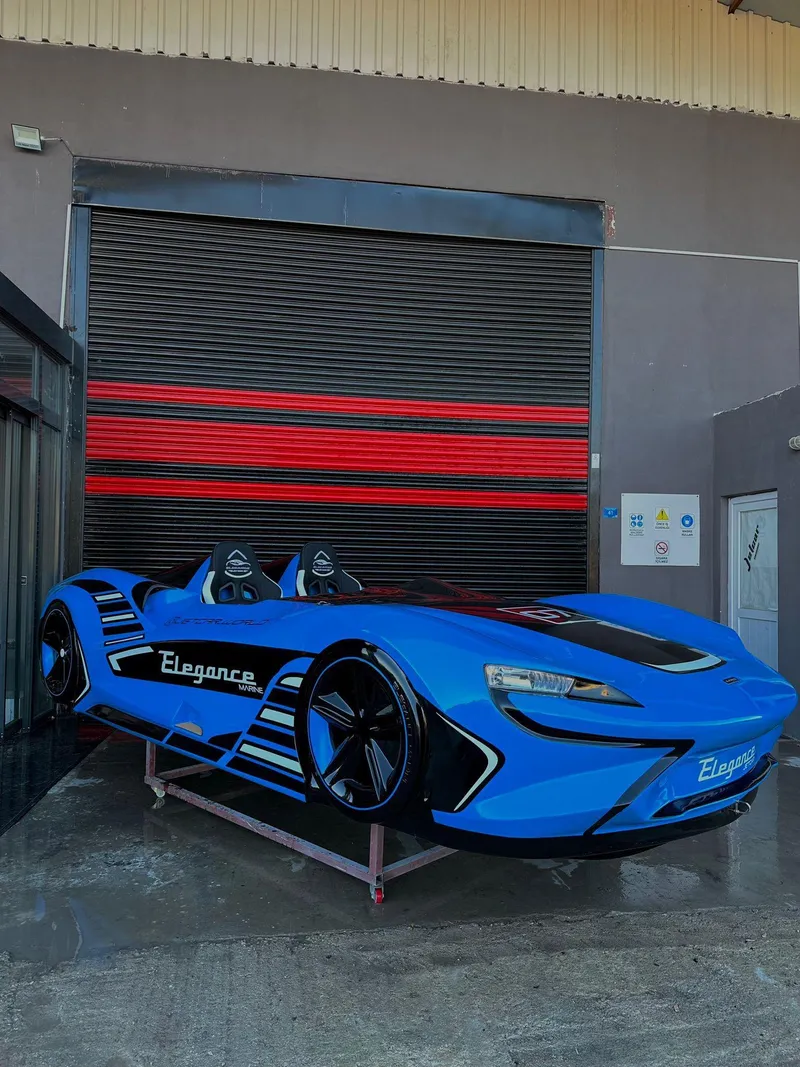 Slide: The Image of Fabbro Jet Car RR 2025 in blue, sleek design, parked outside a garage. - 49