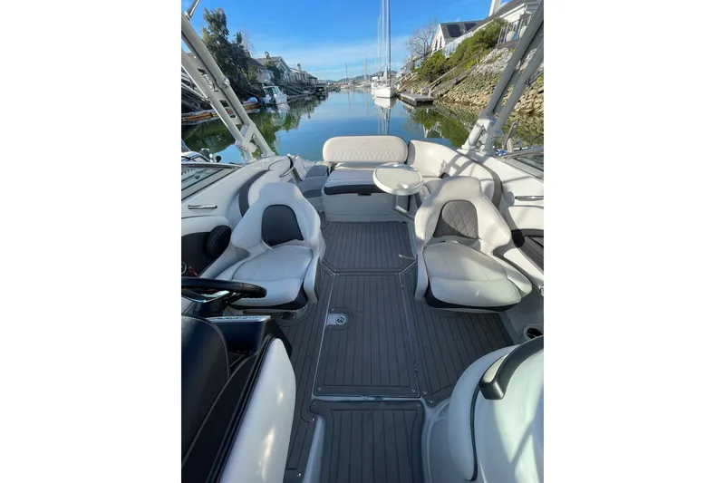Slide: The Image of 2022 Crownline 255 SS SURF boat interior with seating and table, showcasing modern design. - 15
