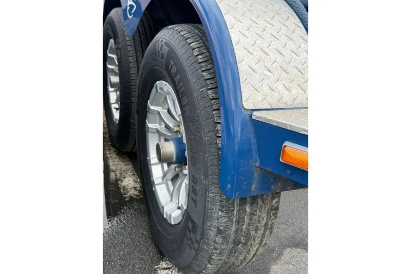 Slide: The Image of Close-up of 2022 Crownline 255 SS SURF trailer wheels with blue fender and diamond plate detail. - 45