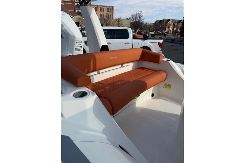 Slide: The Image of 2026 Brig Eagle 6.7 boat with orange seating, parked outdoors. - 3