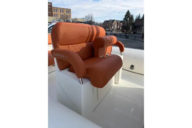 Slide: The Image of 2026 Brig Eagle 6.7 boat seat with orange upholstery, outdoor setting. - 5
