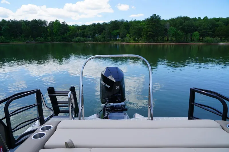 Slide: The Image of 2026 Berkshire 22 UL CTS pontoon boat on a serene lake with lush forest backdrop. - 15