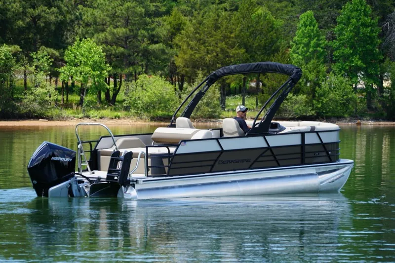 Slide: The Image of 2026 Berkshire 22 UL CTS pontoon boat on a serene lake with lush green trees. - 4