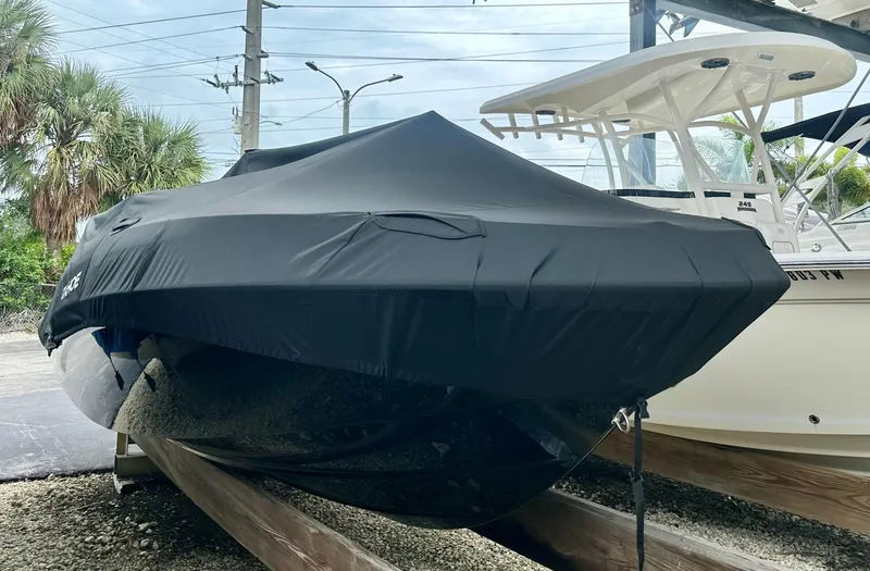 Slide: The Image of 2024 Tahoe T21 boat covered and stored on wooden supports. - 11