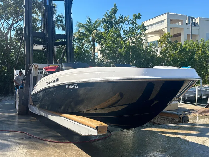Slide: The Image of 2024 Tahoe T21 boat being lifted by a forklift at a marina. - 3