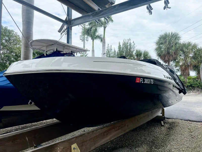 Slide: The Image of 2024 Tahoe T21 boat on a trailer, parked outdoors with palm trees in the background. - 4