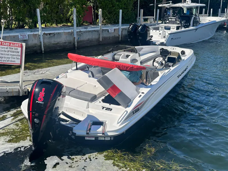 Slide: The Image of 2024 Tahoe T21 boat docked at marina with outboard motor. - 5
