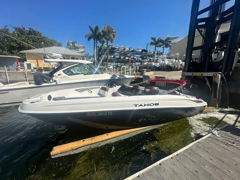 Slide: The Image of 2024 Tahoe T21 boat docked at a marina with palm trees in the background. - 8