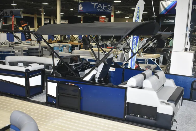 Slide: The Image of 2026 Premier 250 Intrigue RLO - CL pontoon boat displayed at an indoor boat show. - 3
