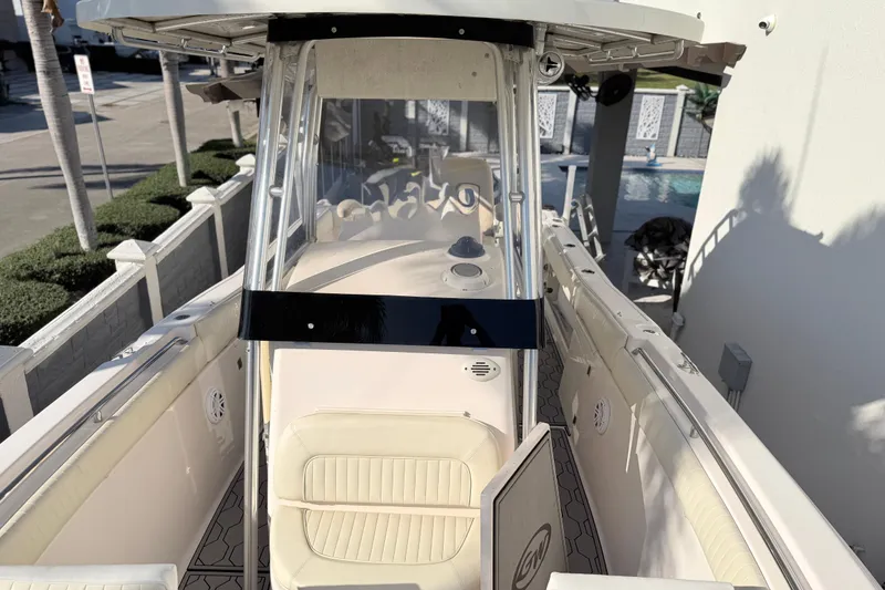 Slide: The Image of 2004 Grady White 273 boat interior with seating and console, docked near a pool. - 112