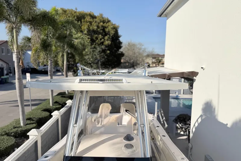 Slide: The Image of 2004 Grady White 273 boat docked near palm trees and a poolside area. - 116