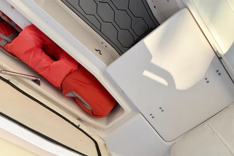 Slide: The Image of Storage compartment with red life jacket on a 2004 Grady White 273 boat. - 130