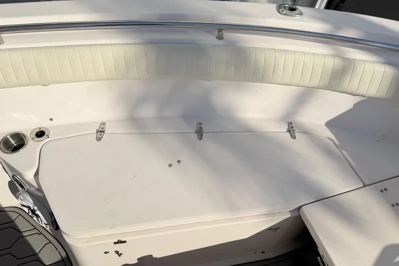 Slide: The Image of 2004 Grady White 273 boat interior with white cushioned seating and stainless steel cup holder. - 132