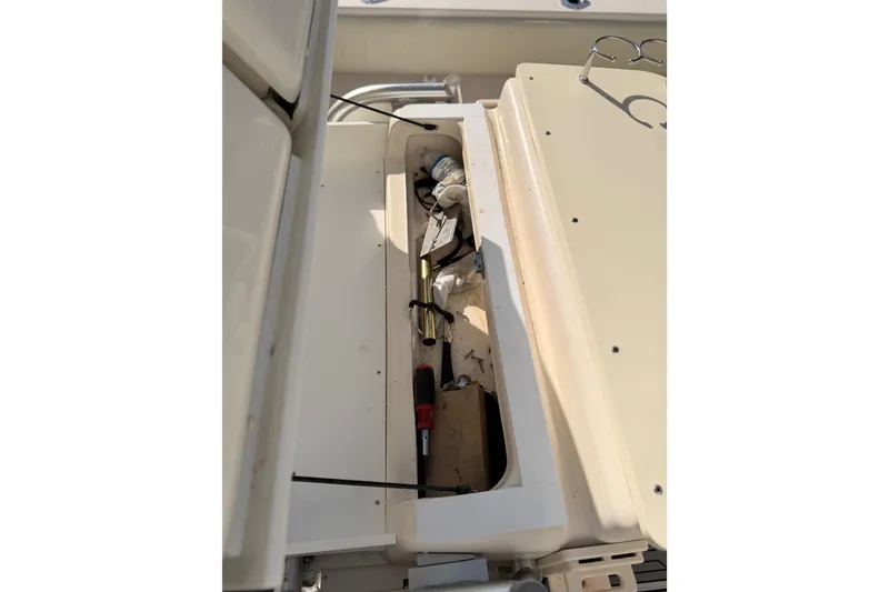 Slide: The Image of Open storage compartment on 2004 Grady White 273 boat with tools and equipment. - 145