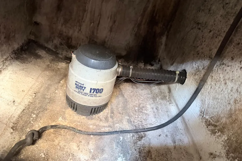 Slide: The Image of 2004 Grady White 273 boat bilge pump, Atwood Heavy Duty 1700, in a weathered compartment. - 150