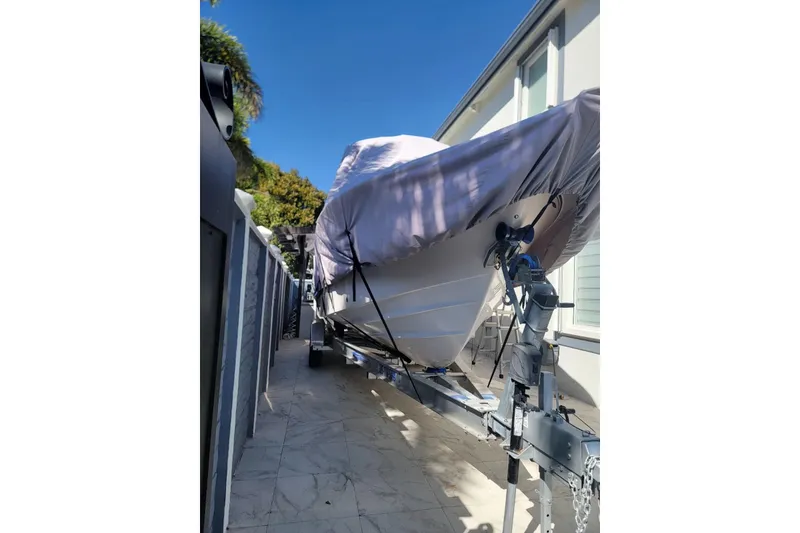 Slide: The Image of Covered 2004 Grady-White Chase 273 boat on trailer, parked beside a house. - 156