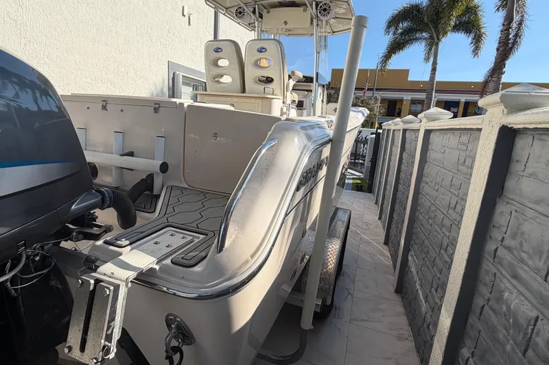 Slide: The Image of 2004 Grady White 273 boat parked beside a wall with palm trees in the background. - 22