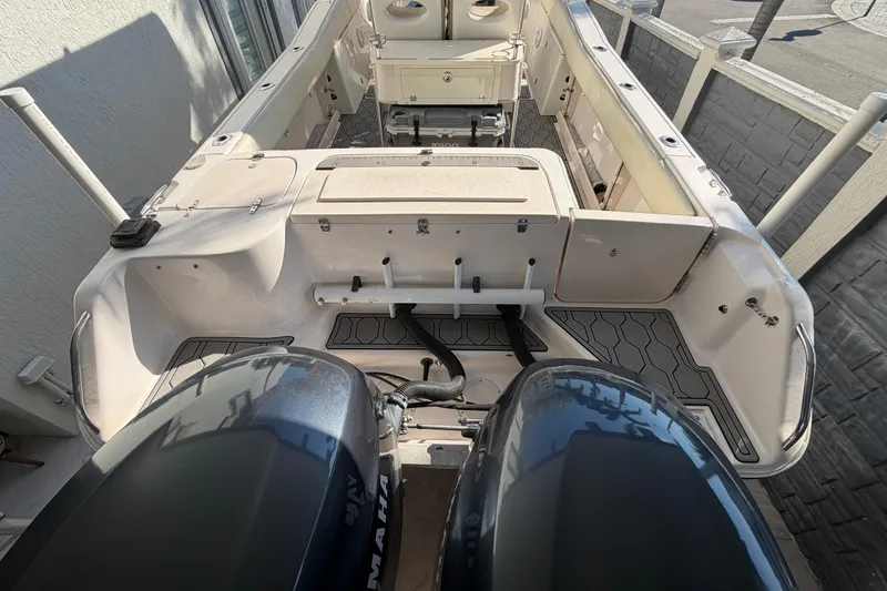 Slide: The Image of 2004 Grady White 273 boat interior with dual Yamaha engines, docked outdoors. - 30