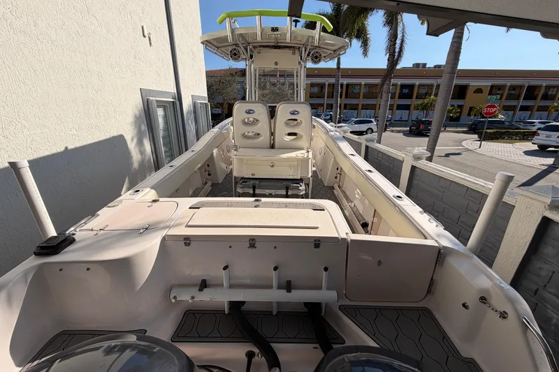 Slide: The Image of 2004 Grady White 273 boat docked, featuring spacious deck and seating, under clear skies. - 31