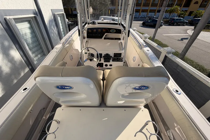 Slide: The Image of 2004 Grady White 273 boat interior with steering wheel and seating, docked near a building. - 41