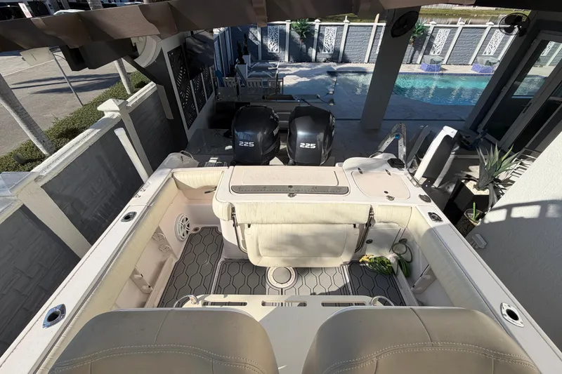 Slide: The Image of 2004 Grady White 273 boat with twin 225 engines, docked near a poolside patio. - 42