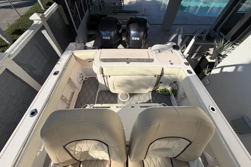 Slide: The Image of 2004 Grady White 273 boat interior with dual 225 engines, beige seating, and deck view. - 43