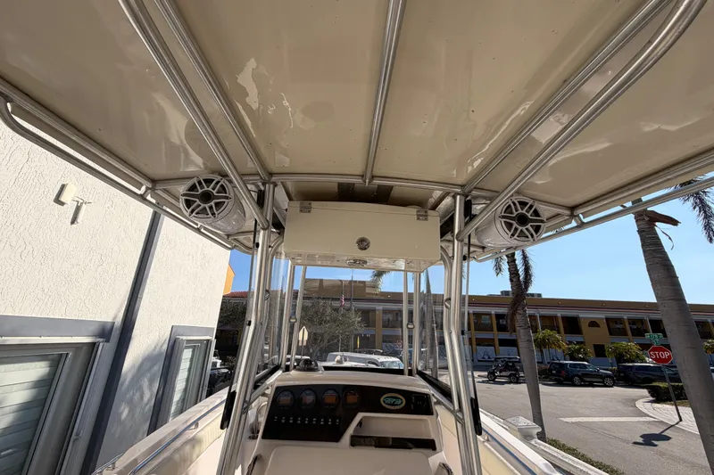 Slide: The Image of 2004 Grady White 273 boat interior with speakers and control panel, docked near palm trees. - 50