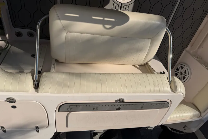 Slide: The Image of 2004 Grady White 273 boat seat with white upholstery and metal supports. - 62