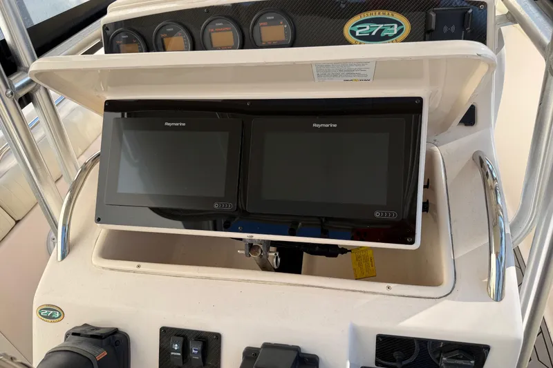 Slide: The Image of 2004 Grady White 273 boat dashboard with Raymarine displays and gauges. - 73