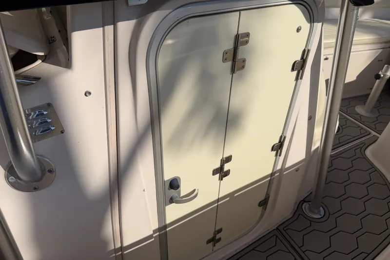 Slide: The Image of 2004 Grady White 273 boat cabin door with metal hinges and textured flooring. - 84