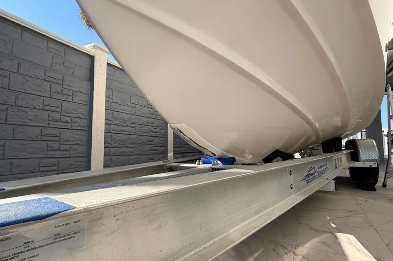 Slide: The Image of 2004 Grady White 273 boat on trailer, viewed from below, against a stone wall background. - 9