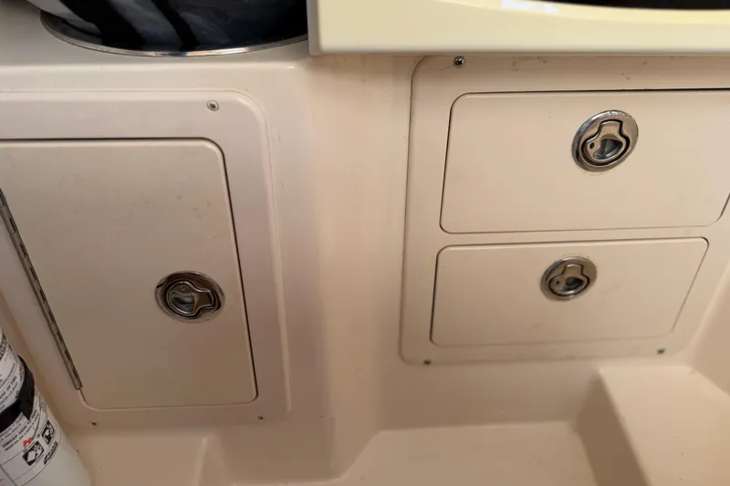 Slide: The Image of 2004 Grady White 273 boat storage compartments with secure latches and fire extinguisher. - 93
