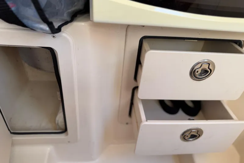 Slide: The Image of 2004 Grady White 273 boat interior with open storage compartments and drawers. - 99